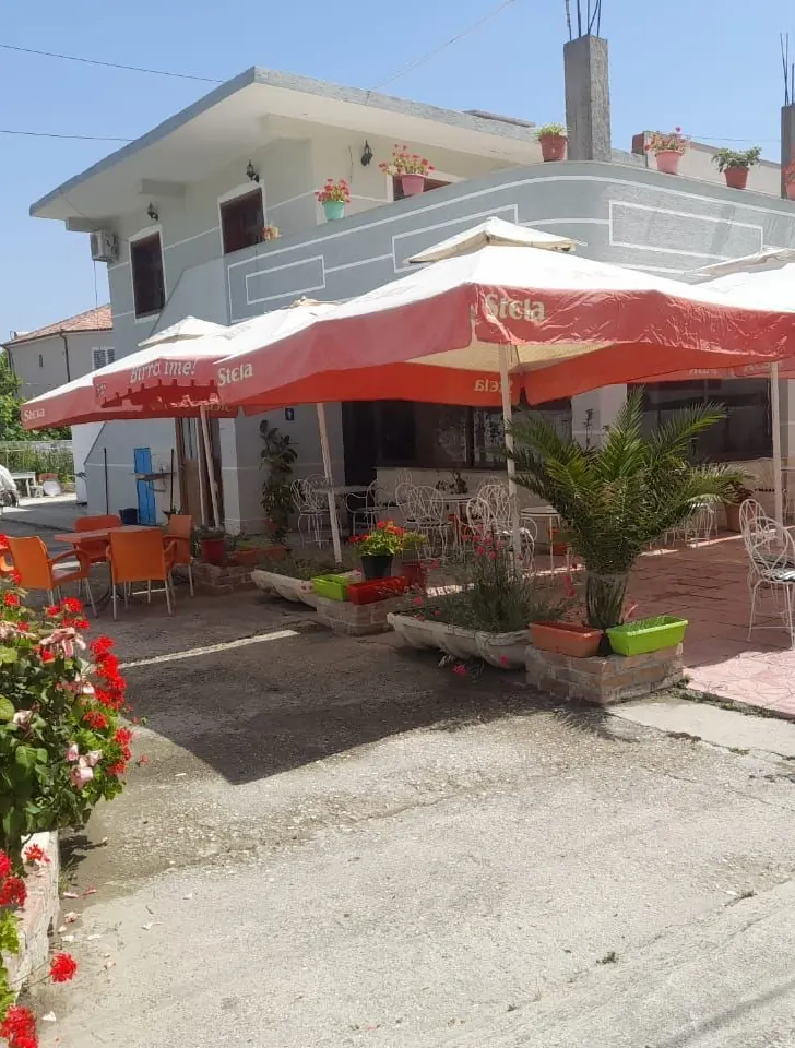 Red geraniums in front of the restaurant and its row of red umbrellas